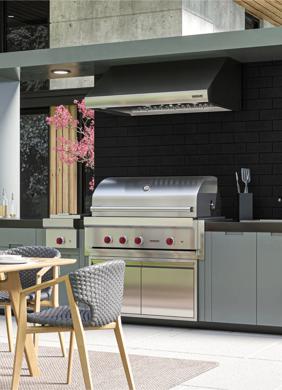 Modern outdoor kitchen equipped with a Wolf grill and a sleek table, designed for elegant outdoor dining experiences