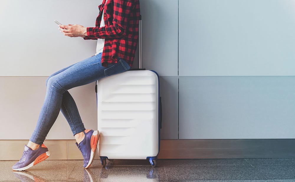 Person sitting on a hardcse suitcase
