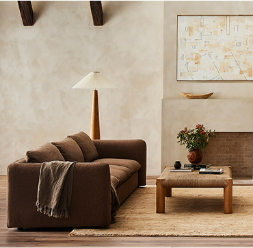 A welcoming living room showcasing a couch, a coffee table, a fireplace, and a plush rug beneath