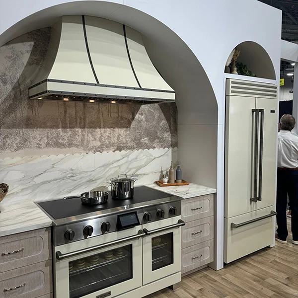 front angle of a cream BlueStar induction range with matching range hood and refrigerator