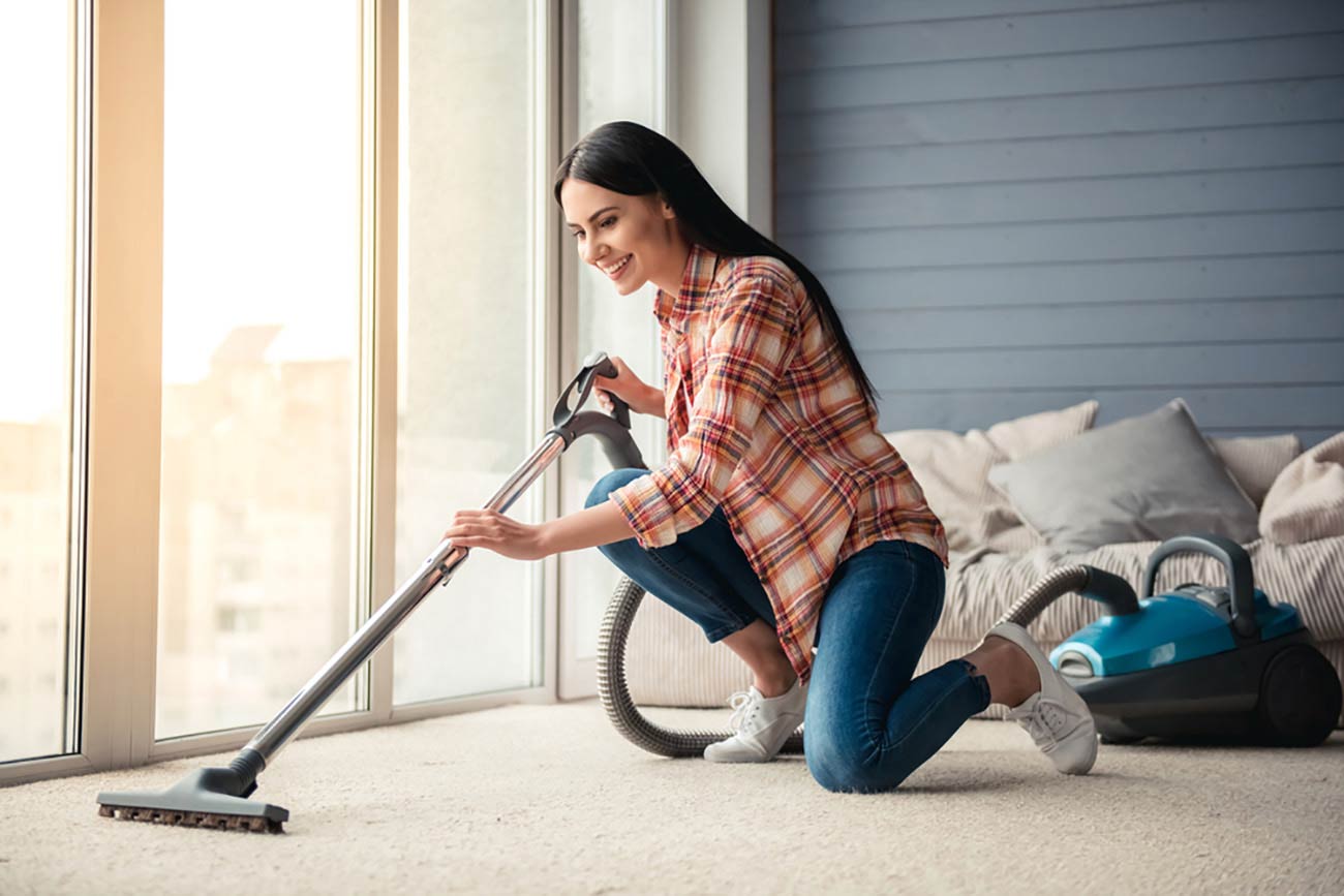 Woman using a Canister Vacuum