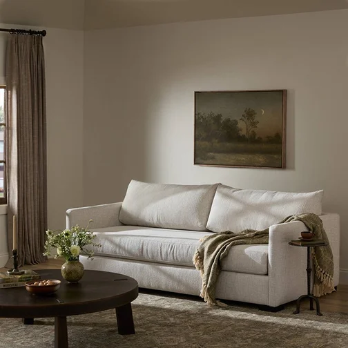 A stylish living room with a comfortable couch, a coffee table, and a soft rug enhancing the space.