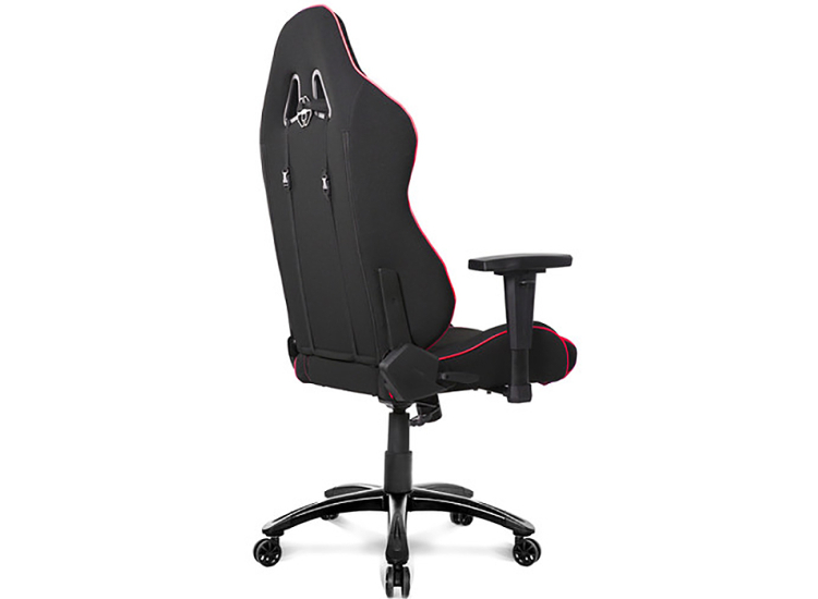 Side view of gaming chair with high back, black fabric, red piping, headrest area visible