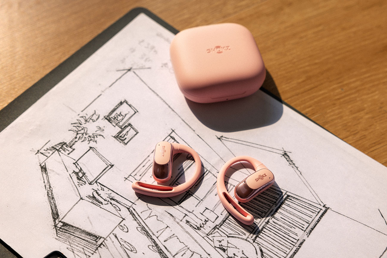Top View of Shoks Open-Ear Earbuds and Case on Desk