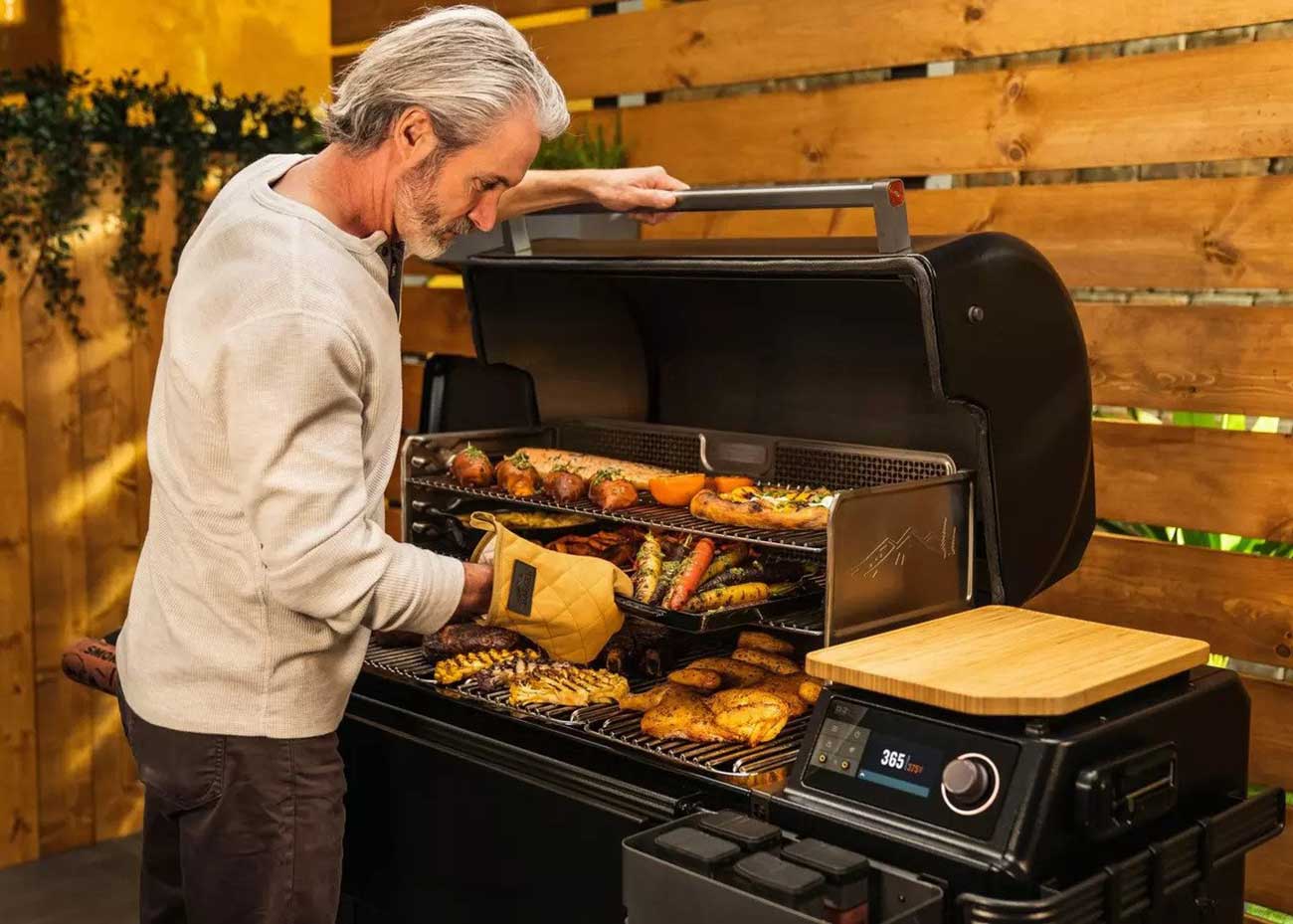 Man Grilling Outside with a Traeger Wood Pellet Grill
