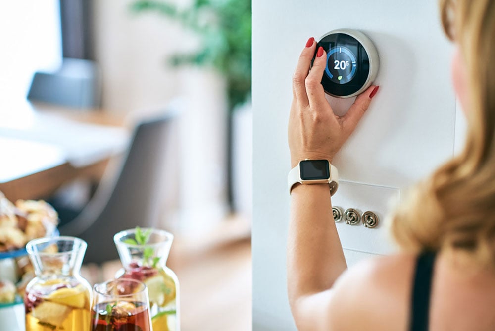 Person adjusting a thermostat