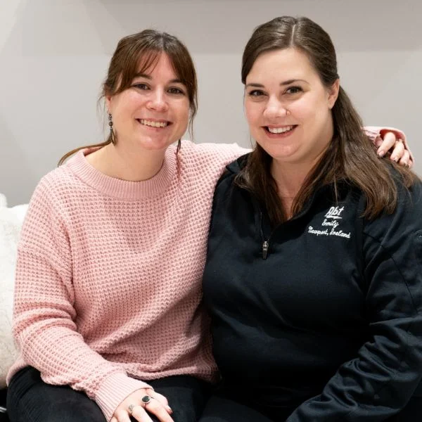 Sarah and Emily Murray sitting beside each other on a sofa