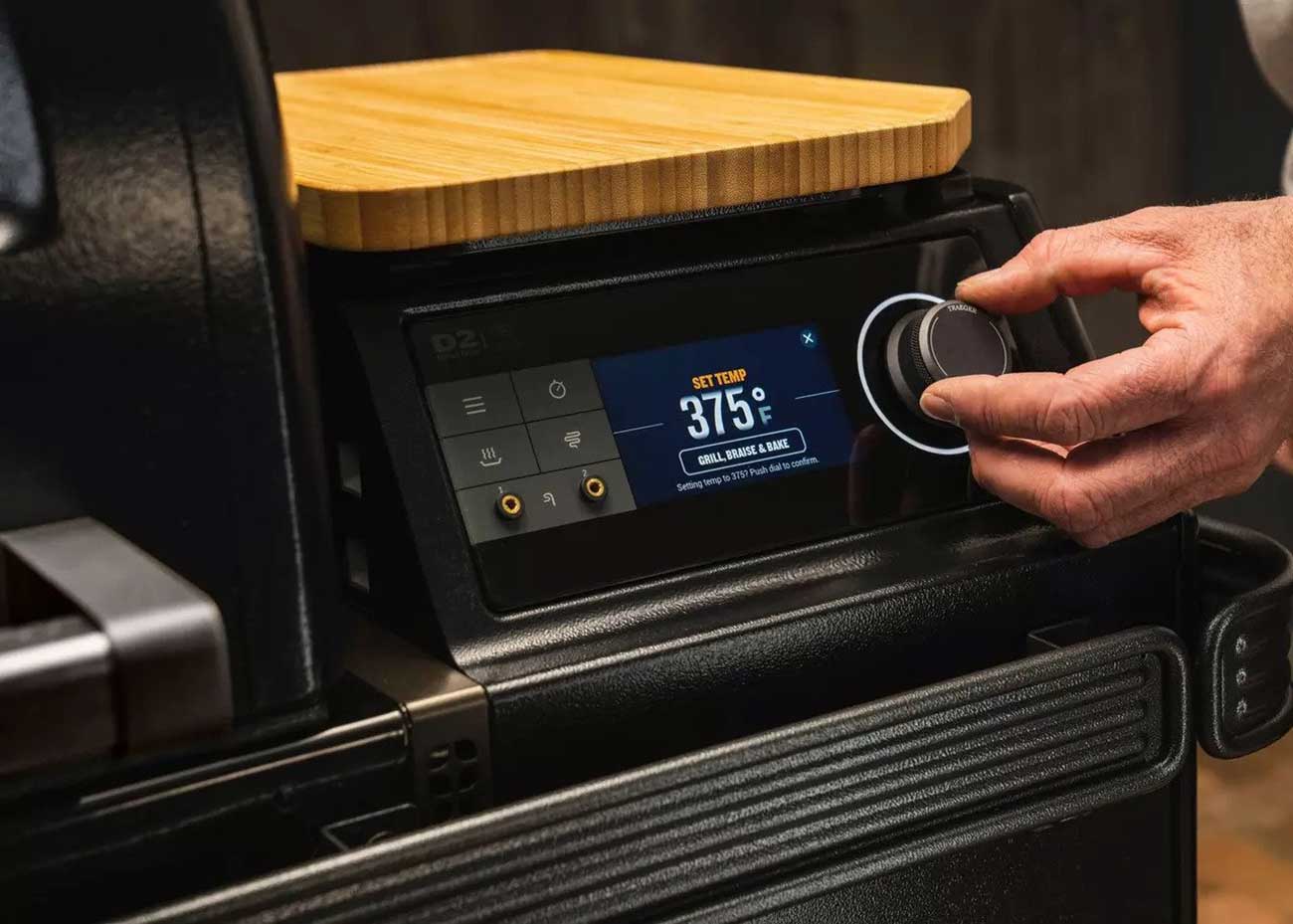 Person Setting the Temperature on a Traeger Wood Pellet Grill
