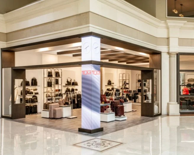 View of the TUMI boutique inside Abt with suuitcases and totes in various colors on shelves, racks and other displays.