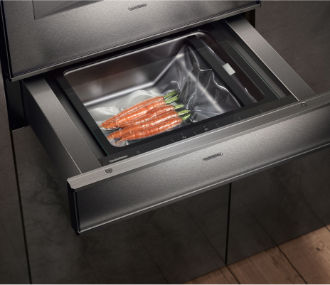 Kitchen featuring a Gaggenau vacuum seal drawer, with a drawer filled with fresh carrots, showcasing innovative food preservation