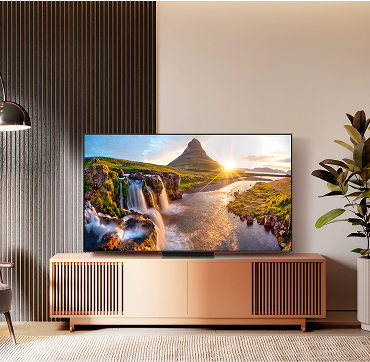 an LG QLED Tv situated atop a wooden tv entertainment stand in a cozy living room setting