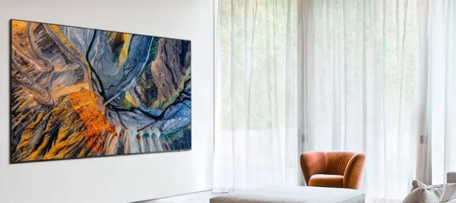 Samsung The Wall displaying a landscape from above in a white living room with long curtains in front of the window