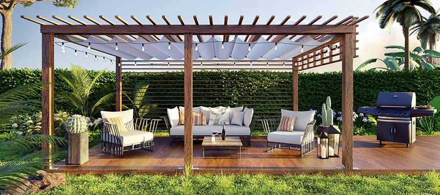 An outdoor patio with wooden flooring, an outdoor grill, white patio furniture and a wooden pergola covering it.
