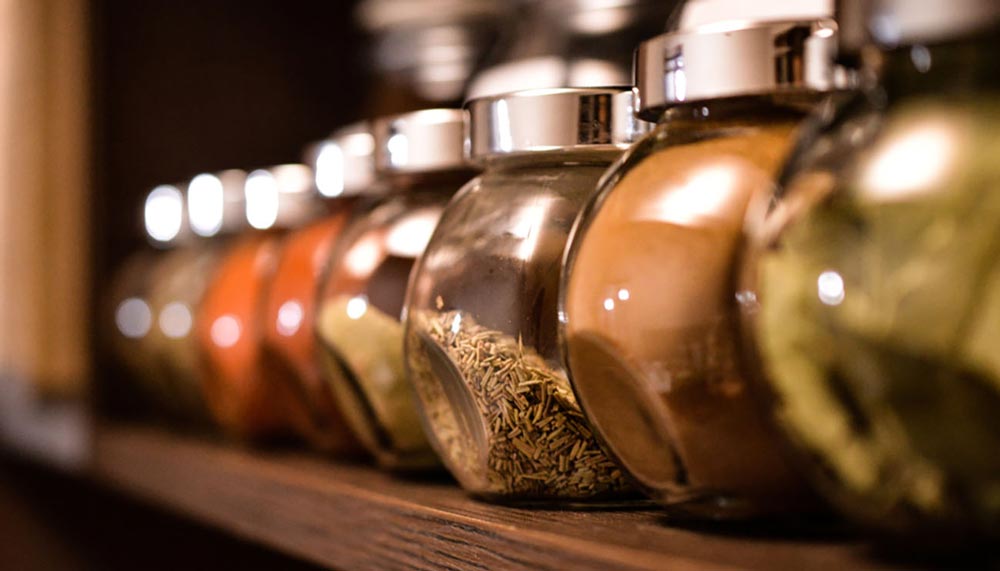 Glass spice jars organized in a kitchen cabinet