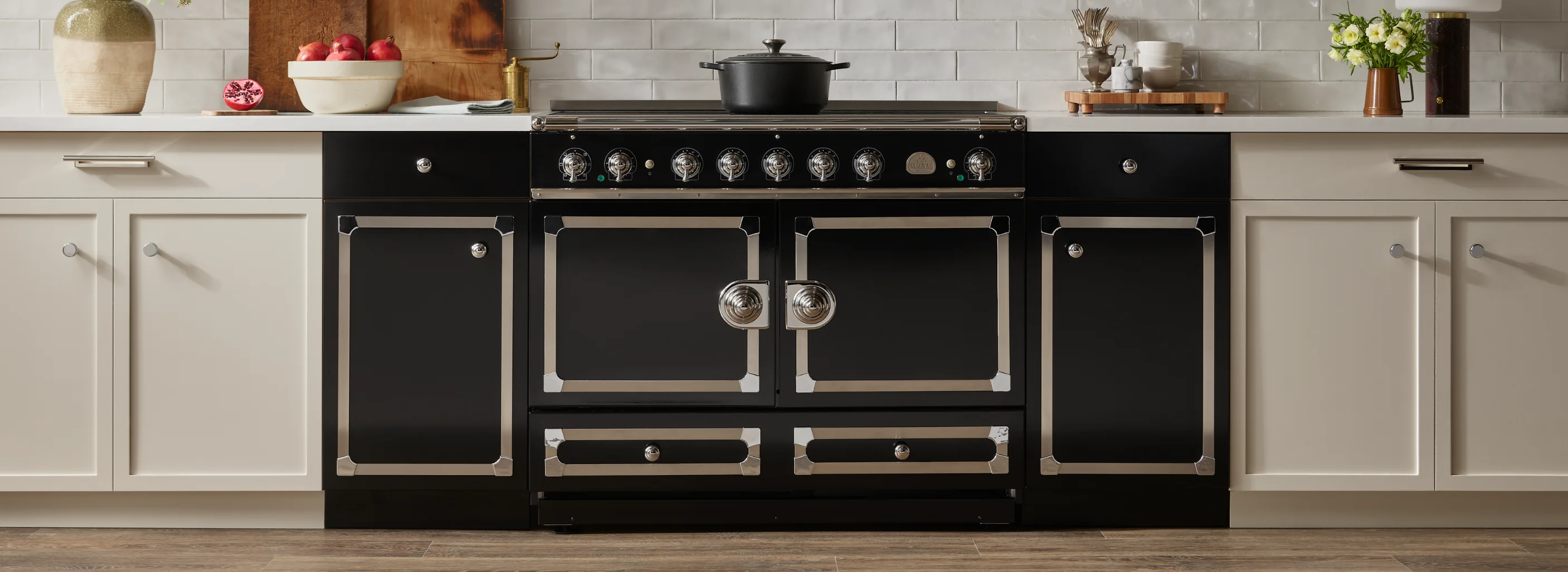 Black La Cornue range in a kitchen with white subway tile and cream cabinetry