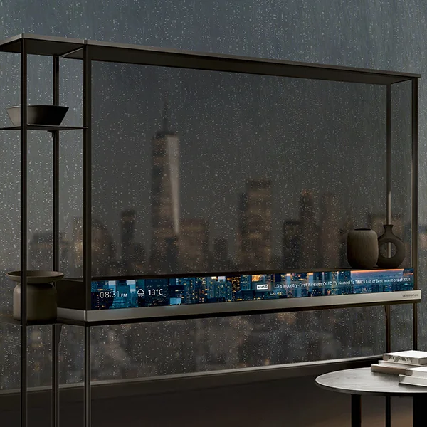 The LG OLED T sitting in front of a dark rain-covered window with the bottom T bar displaying the time of day and the weather