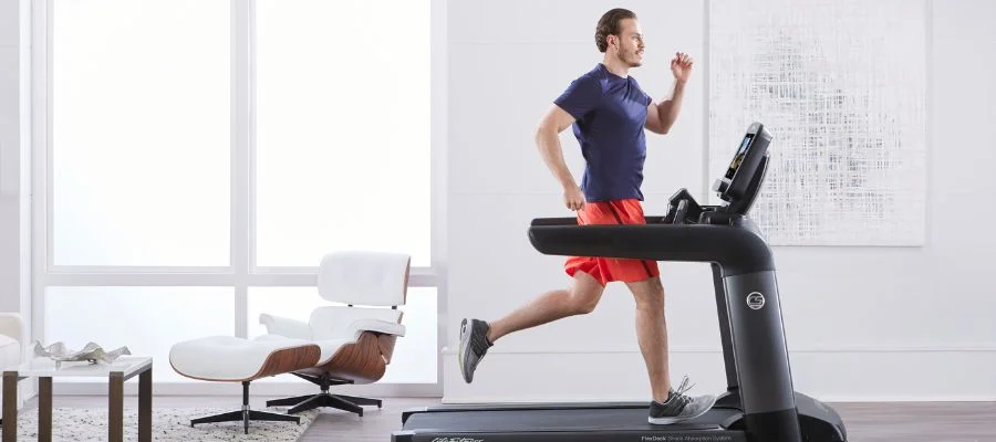 A man running on a treadmill at home.