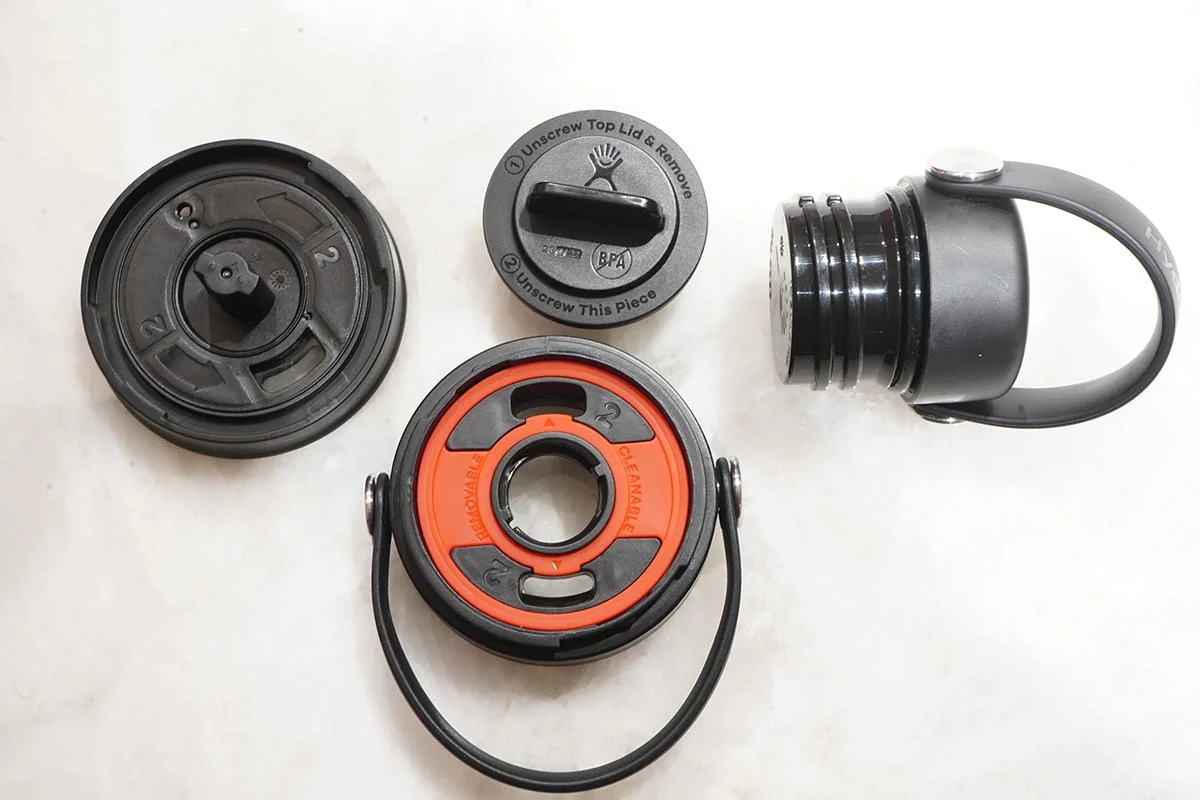 Aerial view of a disassembled Hyrdo Flask Flex Sip lid on a white counter