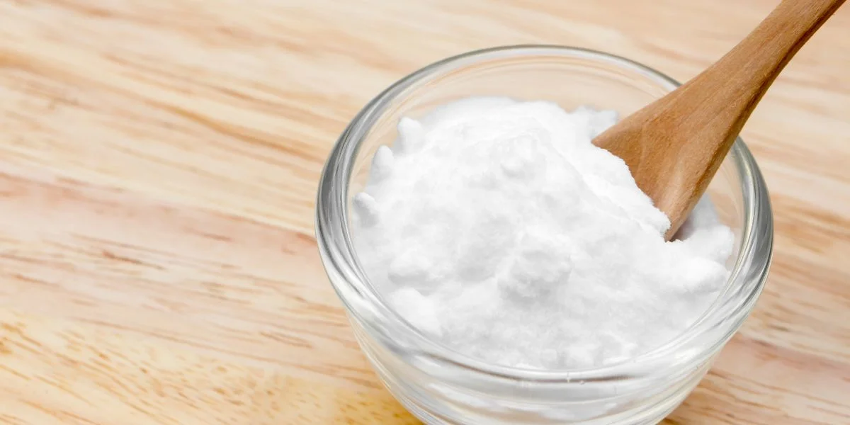 A bowl of baking soda with a wood spoon