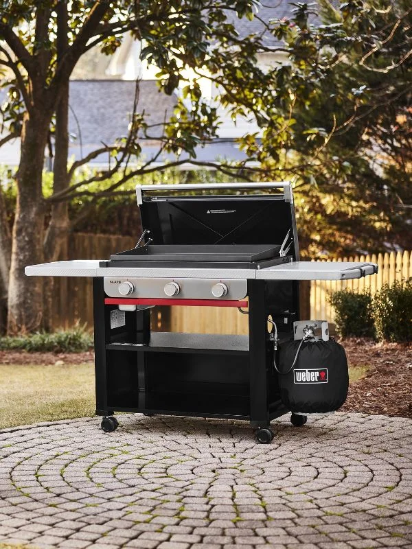 Honed in shot on a Weber Flat Top Griddle open in a nice backyard setting
