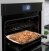 Lifestyle image of oven with food on rack #3.