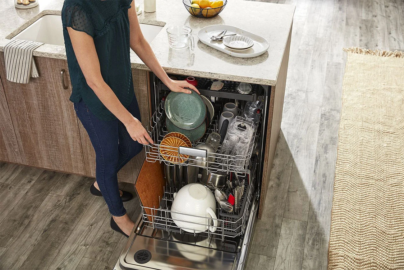 Woman Loading Dishes in a Stainless Steel KitchenAid Dishwasher