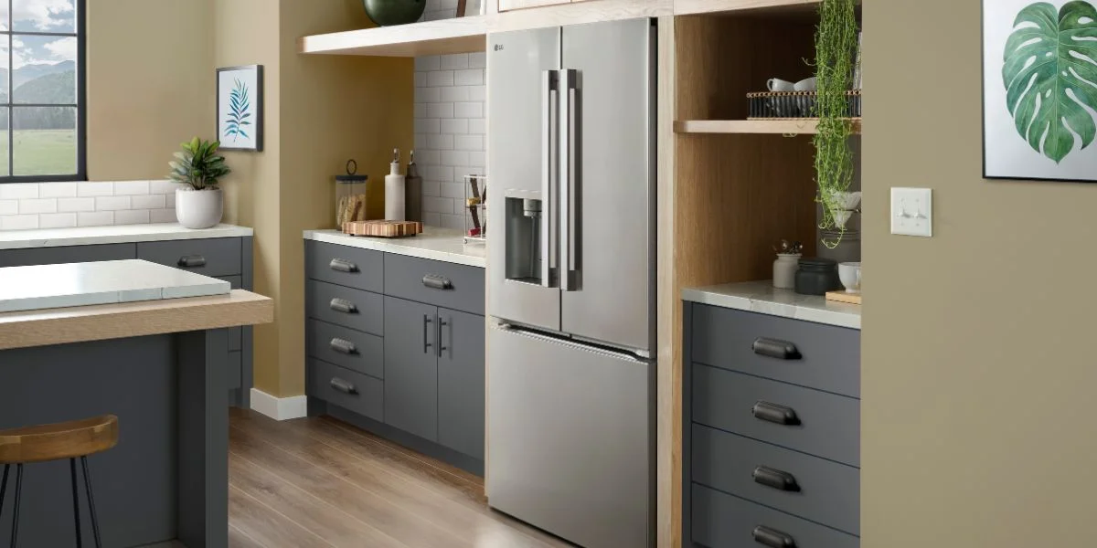 A stainless steel counter-depth French door refrigerator in a gray kitchen.
