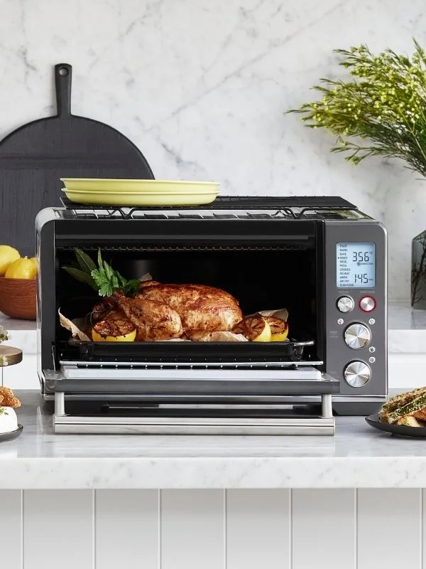 Tight shot on a Breville Air Fryer with a roasted chicken cooking