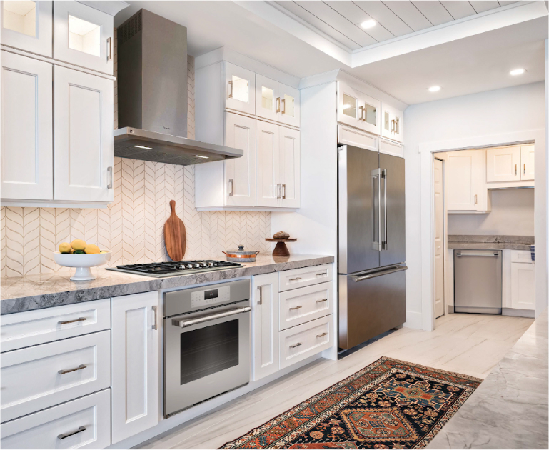 Modern kitchen with white cabinets, a sleek stainless steel oven, and a complete Thermador appliance package, including a refrigerator, stove, dishwasher and rangehood
