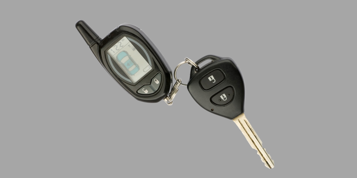 A black car key with an LCD car alarm fob attached to it