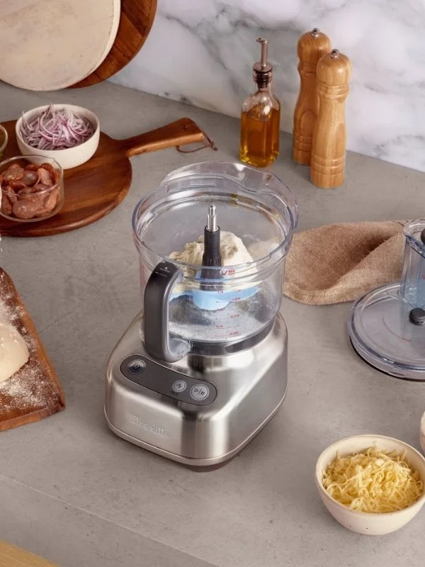 overhead image of a breville food processor with dough inside showcasing making homemade crust in the food processor