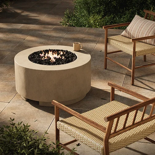 Outdoor fire pit on a patio with two chairs arranged around it, creating a cozy gathering space