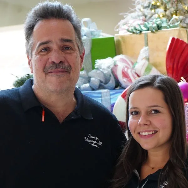 George and Maria Mavriganis in front of a holiday display
