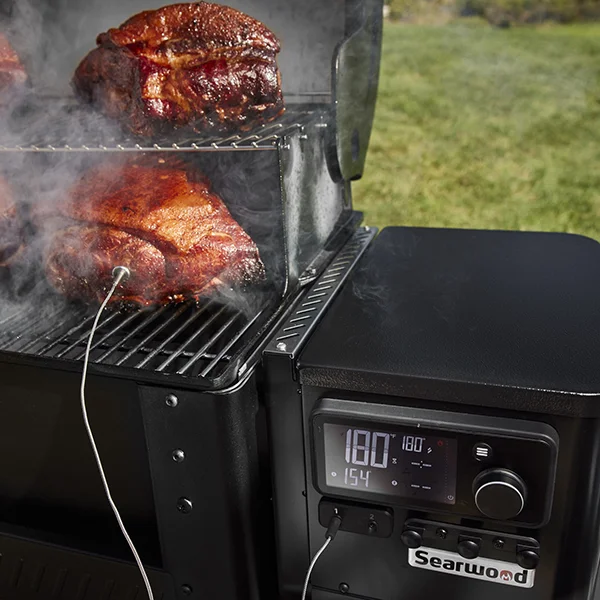 The Weber Searwood 600 grilling whole chickens, while the meat probe is inserted