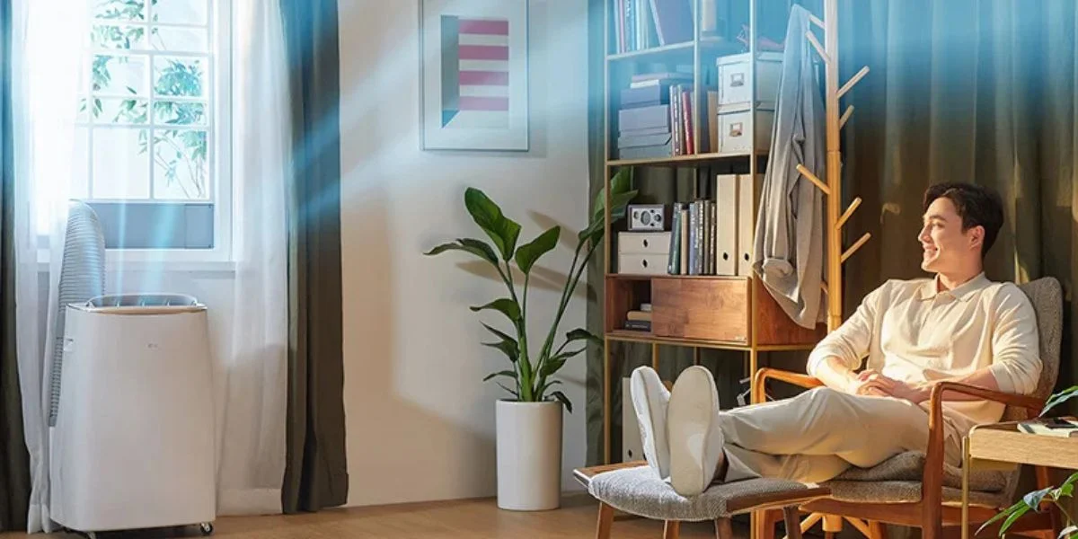 A man relaxing on a chair with an air purifier operating near him.