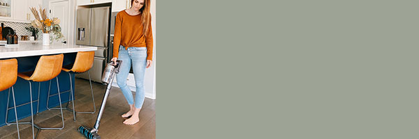 Woman vacuuming floor with cordless vacuum