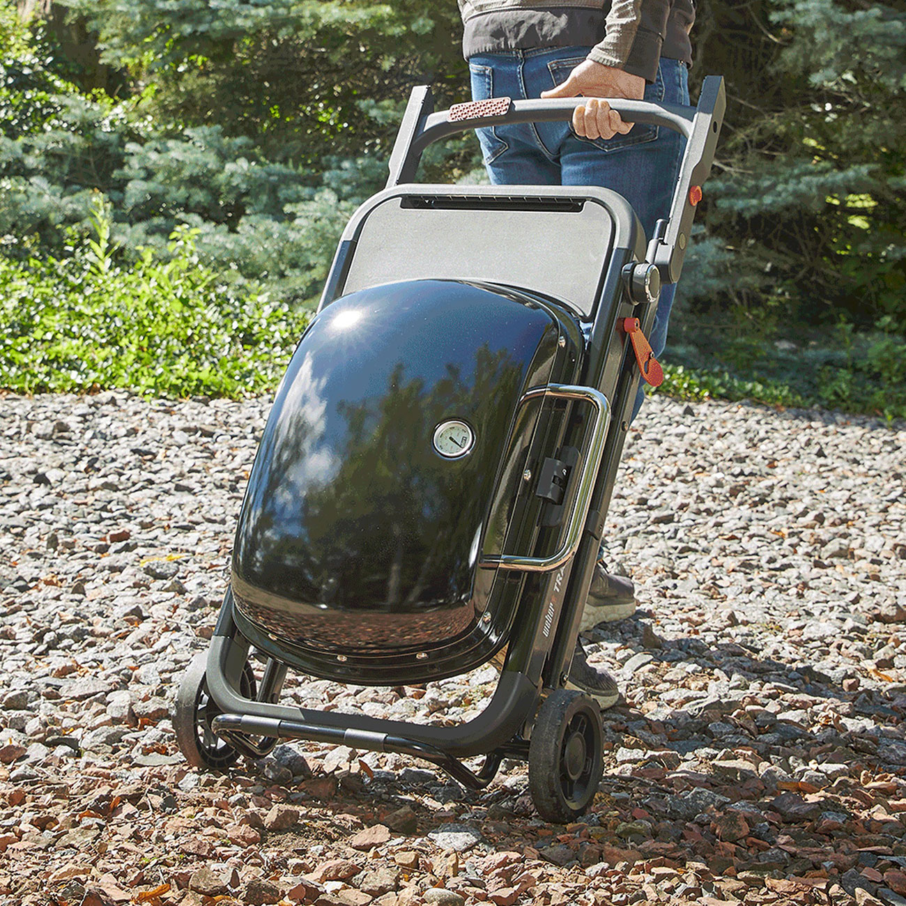 View of Weber Traveler Portable Liquid Propane Gas Grill getting rolled