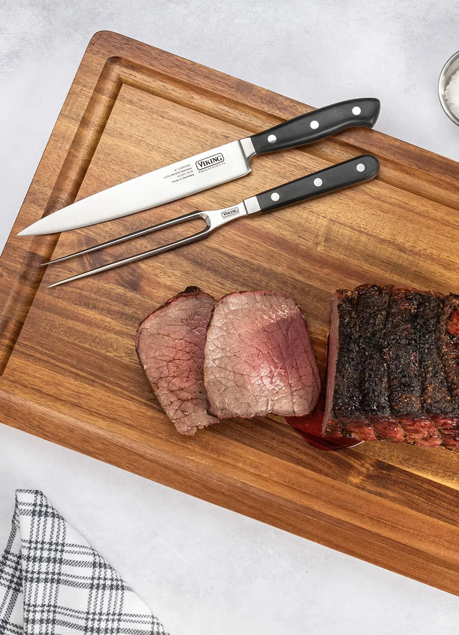 Close-up a viking knife and viking cutting board with sliced meat next to it