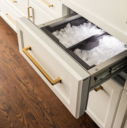 Hand scooping ice from dual ice maker bins in a Thermador refrigerator