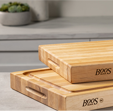 Close up shot of Two Boo's block wooden cutting boards stacked atop each other emphasizing their durability and style for food preparation