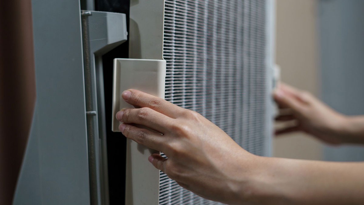 Close-up of a hand removing the grill on the front of an air purifier