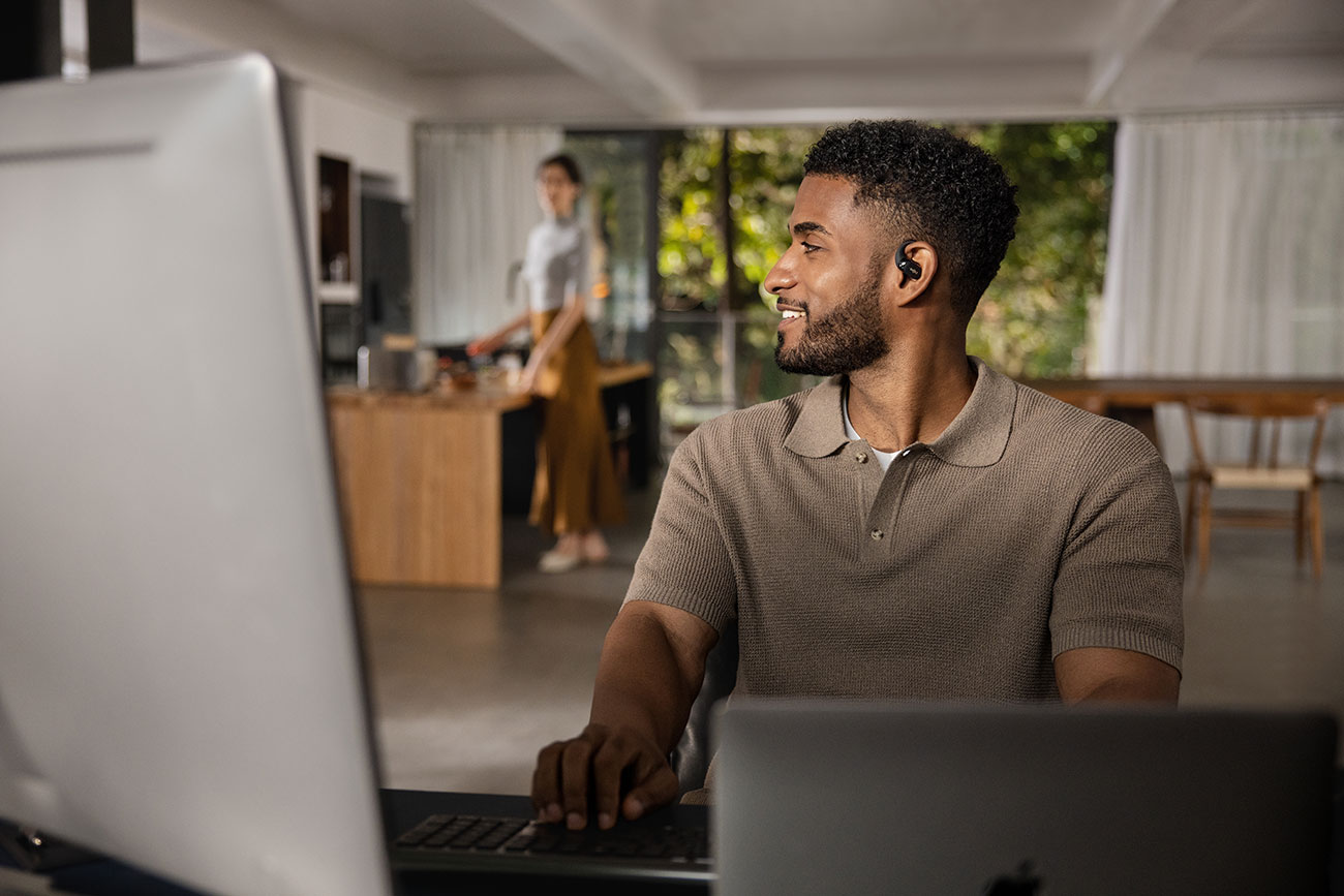 Man Wearing Shokz Open-Ear Earbuds Indoors