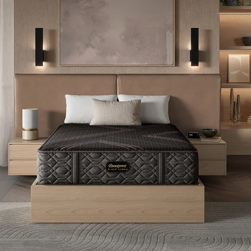A bedroom scene showcasing a mattress on a bed next to a bedside table with decorative items.