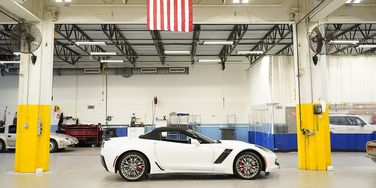 A white sports car parked in the Abt mobile install garage