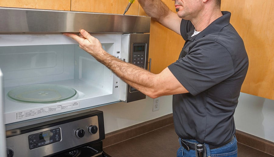 Man Replacing Over the Range Microwave