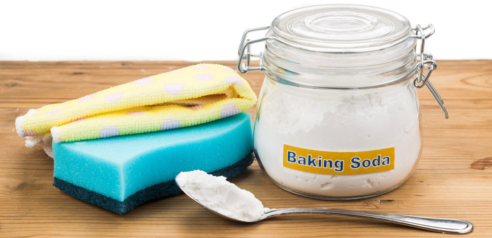 Baking soda with sponge and towel for effective and safe house cleaning