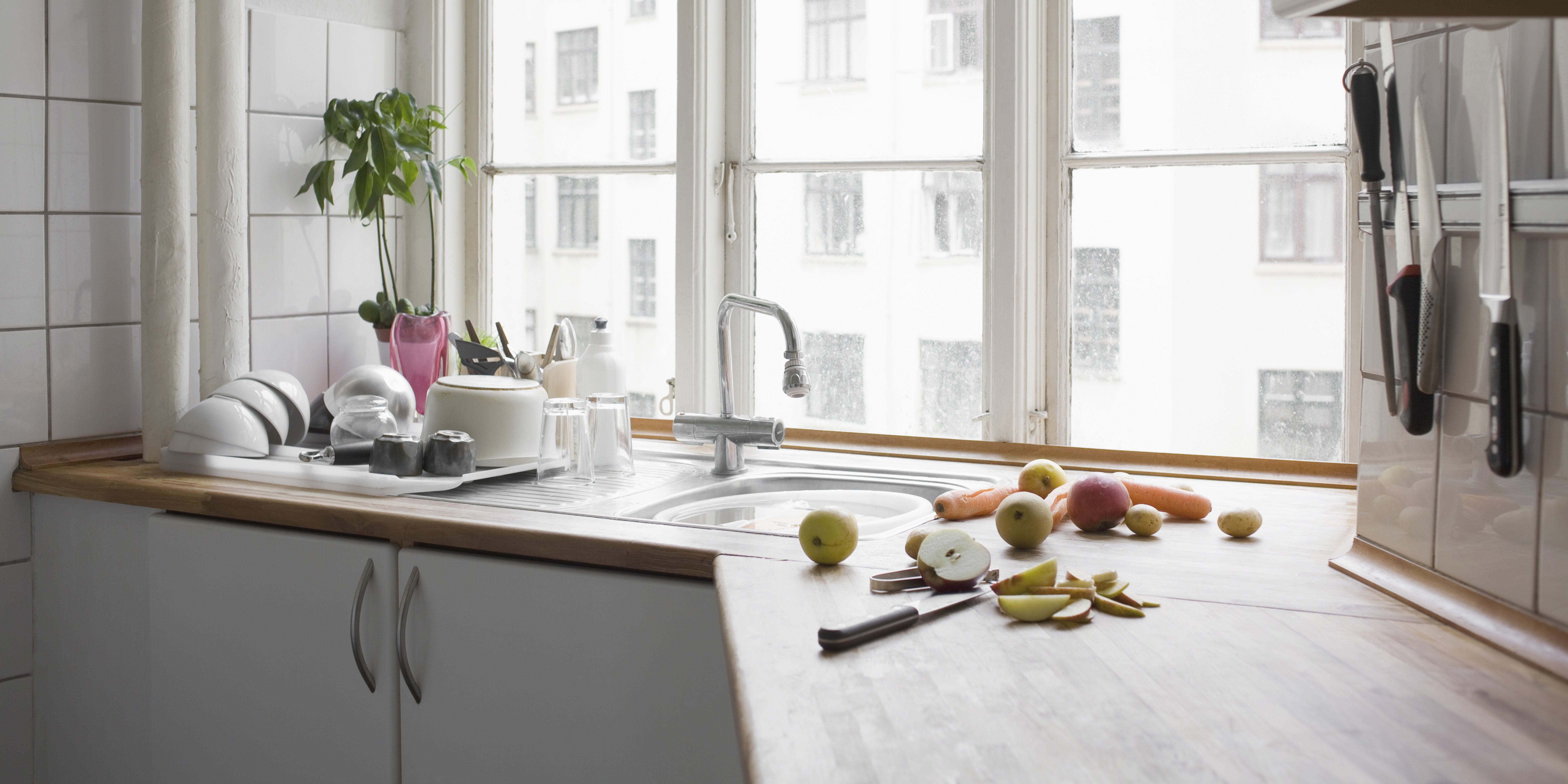 Knives hanging from a magnetic strip in a small kitchen