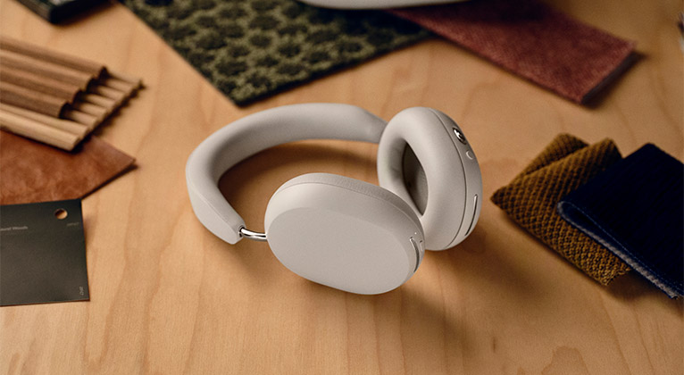 Sonos Ace Headphones in soft white laying flat on a wooden table