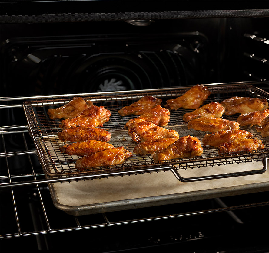 Close-up wings cooking in a frigidaire gallery range using its air fry built in technology