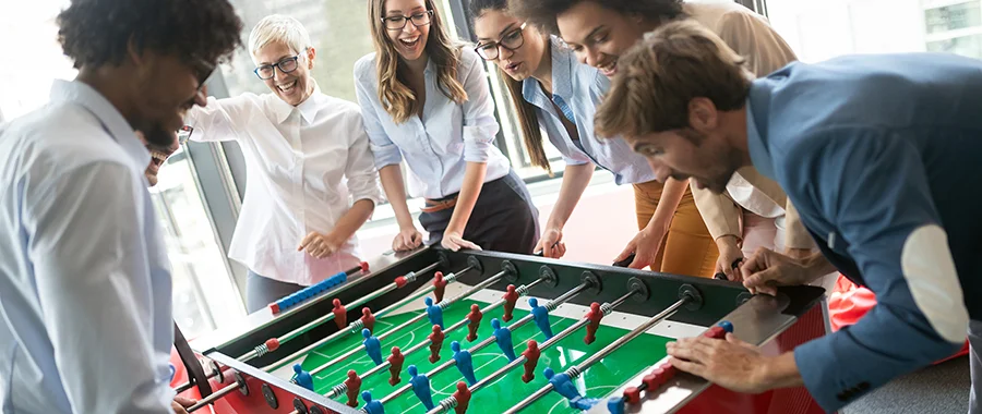 A group of friends playing foosball